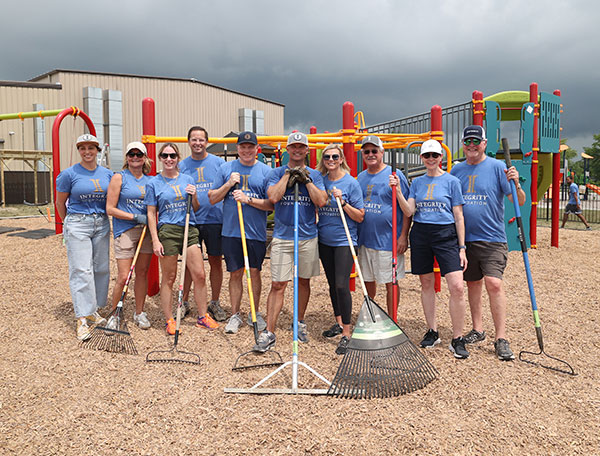 Many people holding rakes after a service project